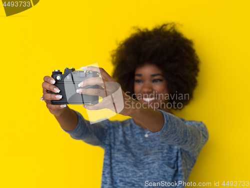 Image of young african american girl taking photo on a retro camera