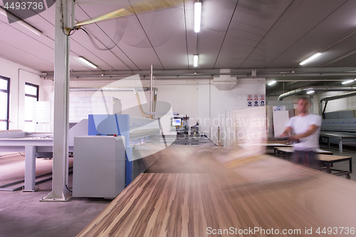 Image of worker in a factory of wooden furniture