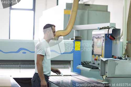 Image of worker in a factory of wooden furniture