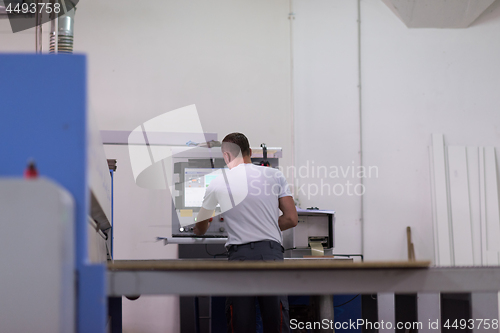 Image of worker in a factory of wooden furniture