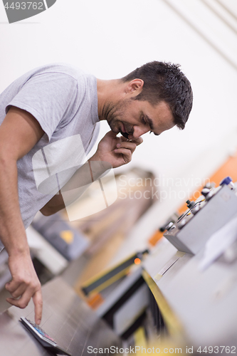 Image of engineer in front of wood cutting machine