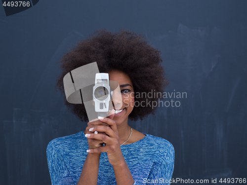 Image of african american woman using a retro video camera