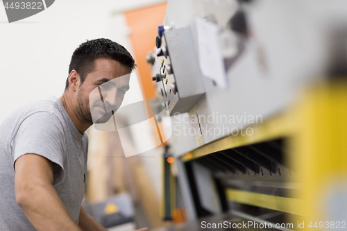 Image of worker in a factory of wooden furniture