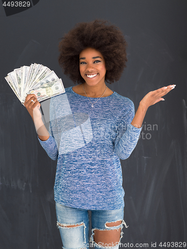 Image of black woman holding money on gray background