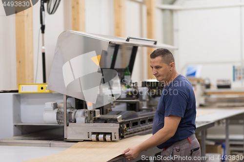 Image of worker in a factory of wooden furniture