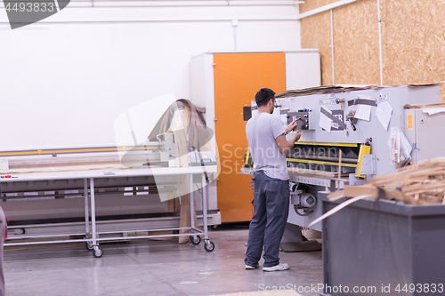 Image of worker in a factory of wooden furniture