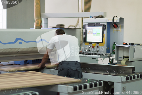 Image of worker in a factory of wooden furniture