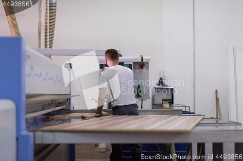 Image of worker in a factory of wooden furniture