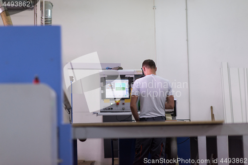 Image of worker in a factory of wooden furniture