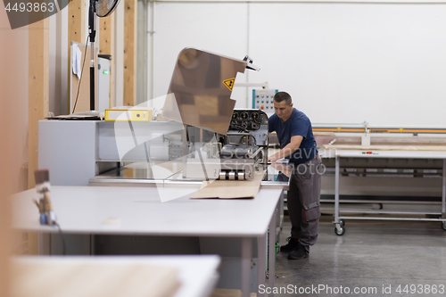 Image of worker in a factory of wooden furniture