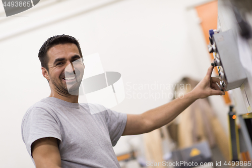 Image of worker in a factory of wooden furniture