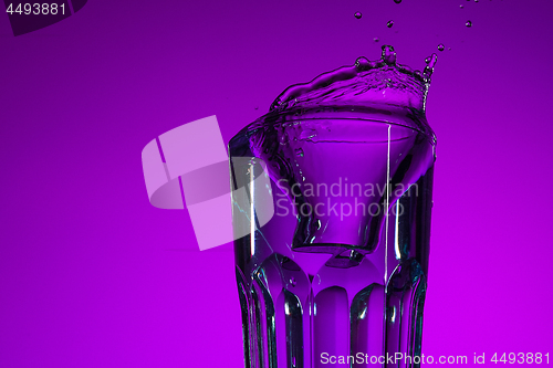 Image of The water splashing in glass on lilac background