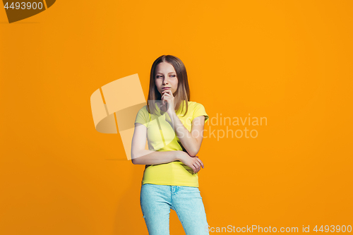 Image of Beautiful teen girl looking suprised and bewildered isolated on orange