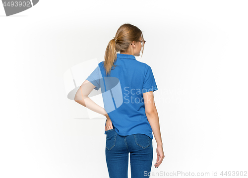 Image of Closeup of young woman\'s body in empty blue t-shirt isolated on white background. Mock up for disign concept