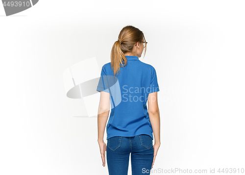 Image of Closeup of young woman\'s body in empty blue t-shirt isolated on white background. Mock up for disign concept