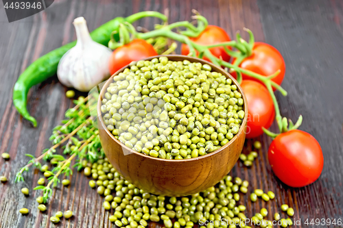 Image of Mung beans  in bowl with vegetables and thyme on dark board