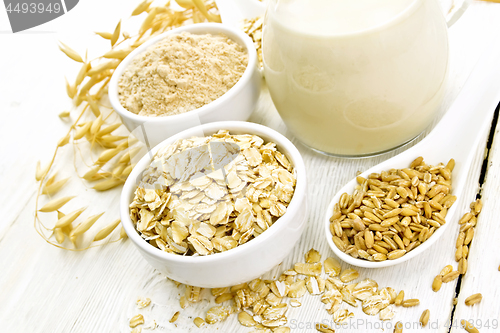 Image of Oat flakes with flour and milk on board