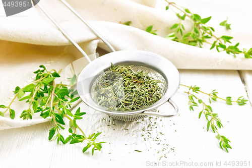 Image of Thyme dry in strainer on board