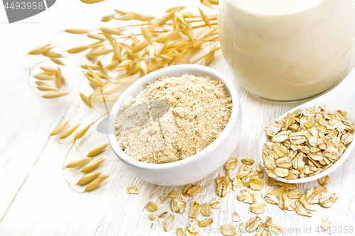 Image of Flour oat in bowl with milk on board