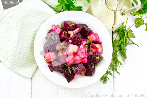 Image of Salad of beets and potatoes in plate on light board top