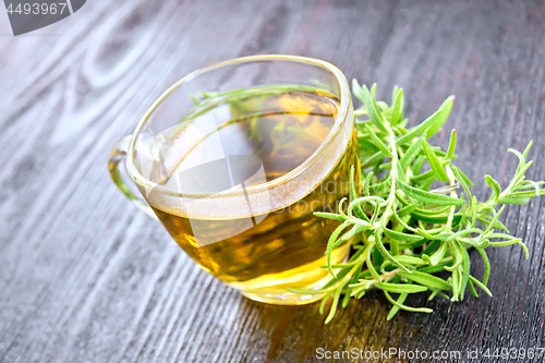 Image of Tea of rosemary in cup on wooden board