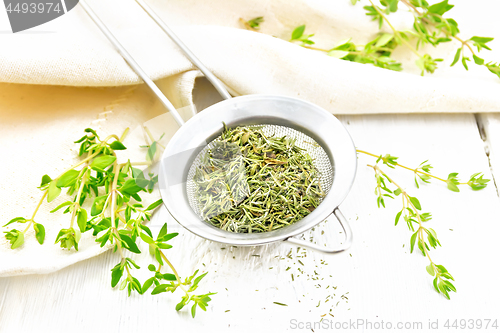 Image of Thyme fresh and dry in strainer on light board