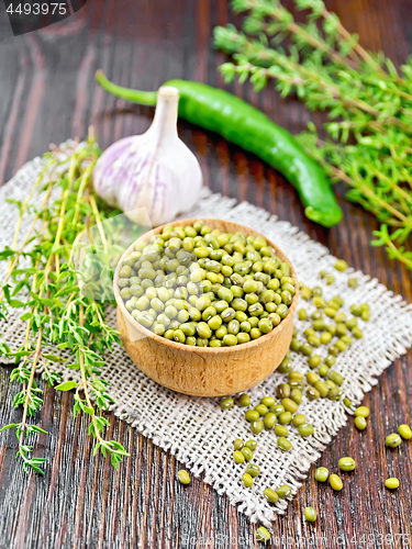 Image of Mung beans in wooden bowl with thyme on board