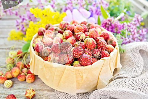 Image of Strawberries in box with flowers on board