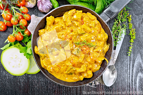 Image of Goulash with tomato and zucchini in pan on black board top