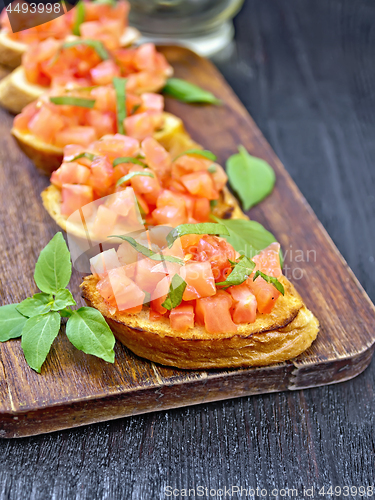 Image of Bruschetta with tomato and basil on table