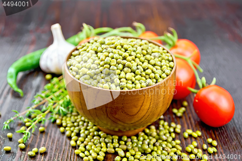 Image of Mung beans  in bowl with vegetables and thyme on wooden board