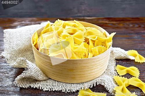 Image of Farfalle in bark box on wooden board