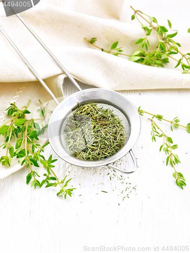 Image of Thyme fresh and dry in strainer on board