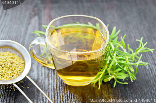 Image of Tea of rosemary in cup with strainer on board