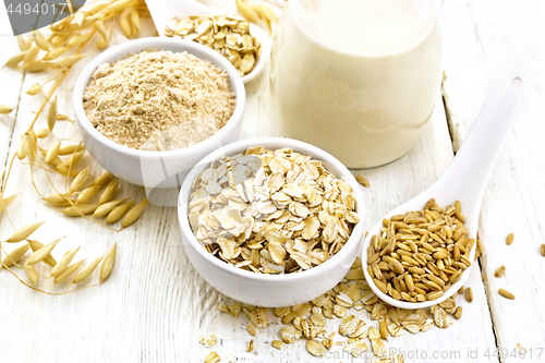 Image of Oat flakes with flour and milk on table