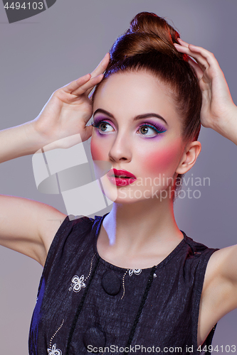 Image of Beautiful girl with hairdo and bright make-up