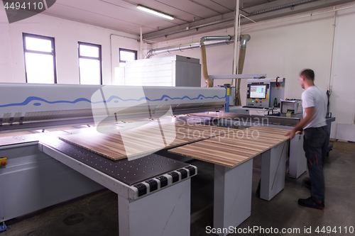 Image of worker in a factory of wooden furniture