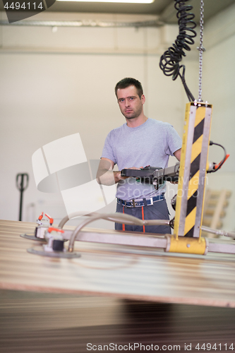 Image of worker in a factory of wooden furniture