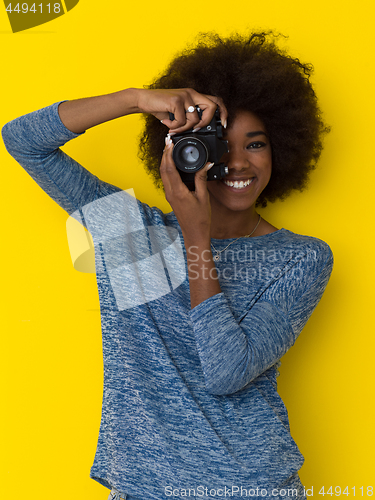 Image of young african american girl taking photo on a retro camera