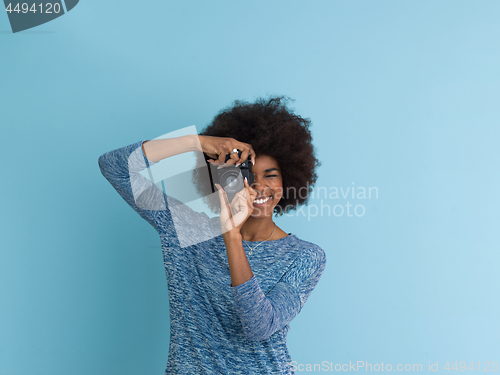 Image of african american girl taking photo on a retro camera