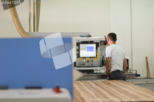 Image of worker in a factory of wooden furniture