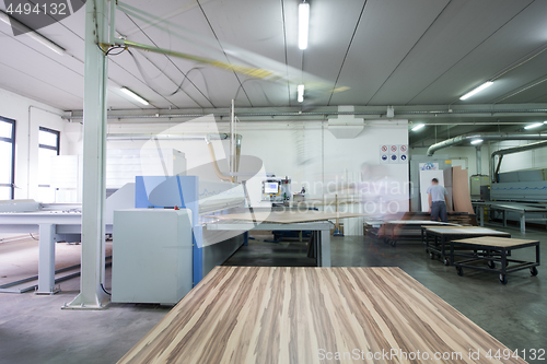 Image of worker in a factory of wooden furniture