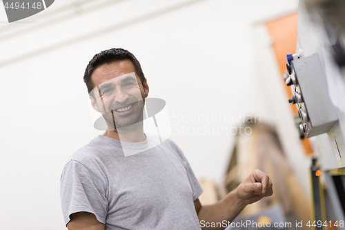 Image of worker in a factory of wooden furniture