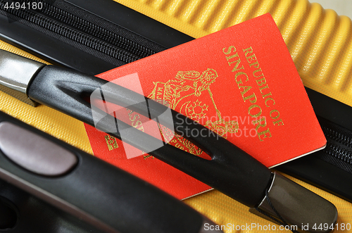 Image of Singapore passport on a yellow suitcase