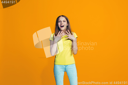 Image of Beautiful teen girl looking suprised isolated on orange