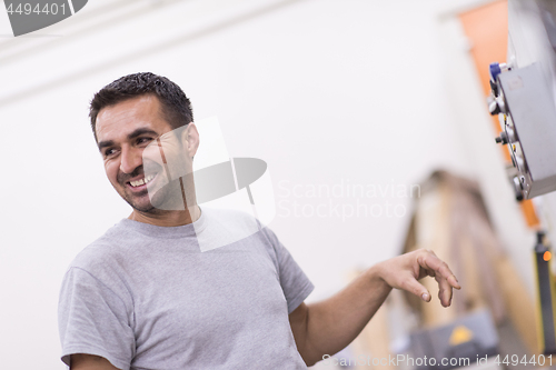 Image of worker in a factory of wooden furniture