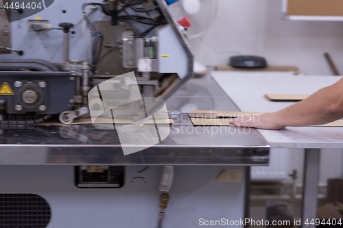 Image of engineer in front of wood cutting machine