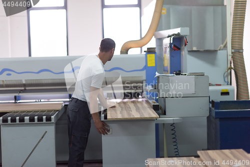 Image of worker in a factory of wooden furniture