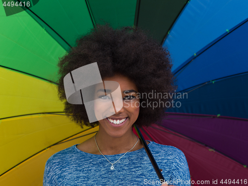 Image of african american woman holding a colorful umbrella