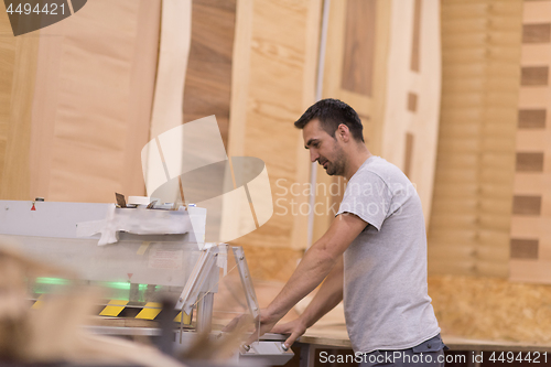 Image of worker in a factory of wooden furniture